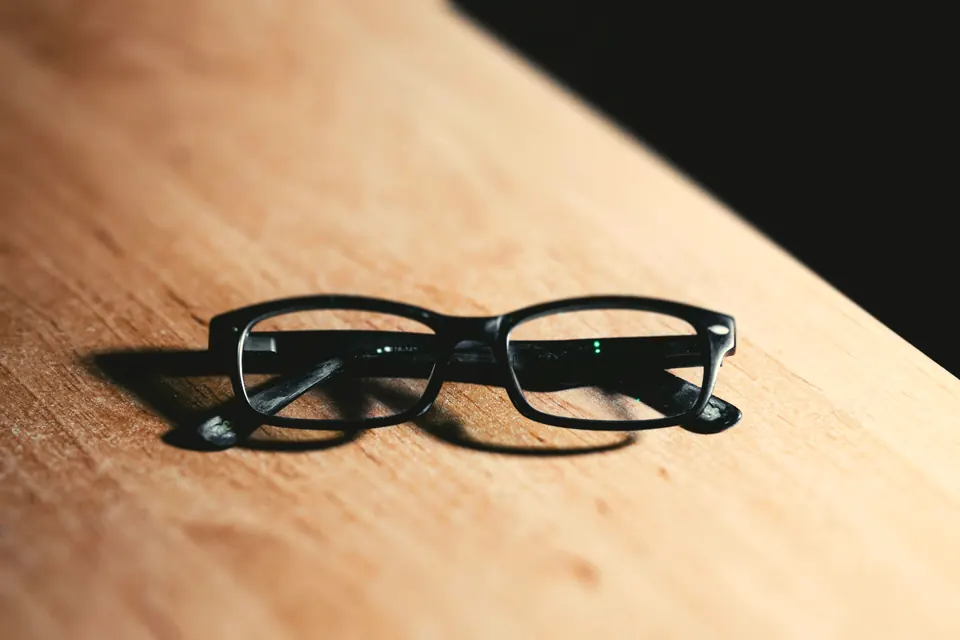 Acetate eyewear frame on a wooden surface — craft detail