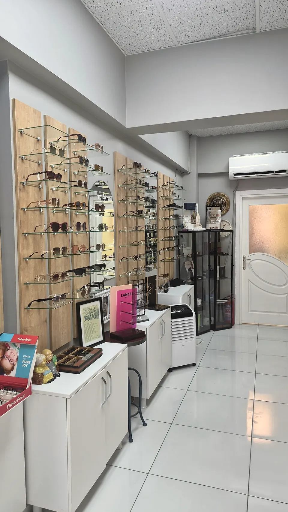 Sinan Optik second wall — Lancel display, family-friendly children's frames, and BVLGARI wall clock