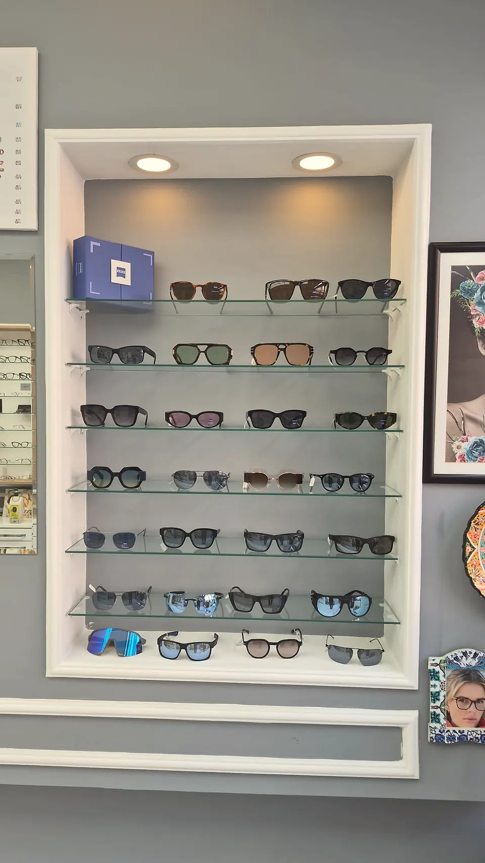 Sinan Optik ZEISS premium niche — backlit glass shelves featuring Zeiss lenses, premium sunglasses and sport silhouettes